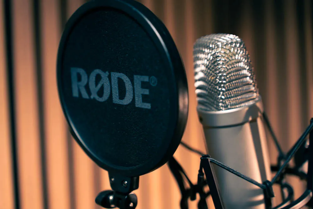 Un micro de studio et son filtre anti-pop, dans la cabine d'enregistrement